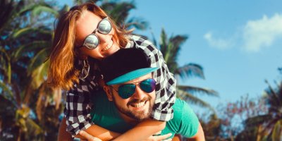 Žena objímá muže v kšiltovce kolem krku