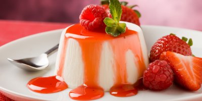 Panna cotta přelitá malinovou omáčkou, maliny, jahody, máta, lžička