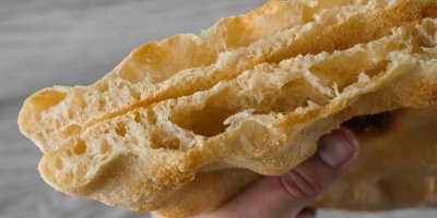 Pohled zblízka na rozkrojené nadýchané těsto pinsy