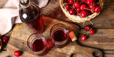 Třešně a likér na dřevěném stole 