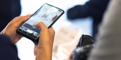 Žena ověřuje QR kód na vstupence pomocí chytrého telefonu