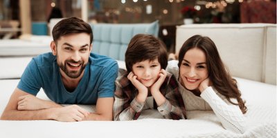 Muž, žena a chlapec leží na matraci v obchodě