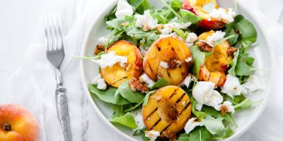 Trhaný salát s čerstvým sýrem, ořechy a grilovanými broskvemi