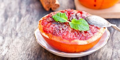 Grilovaný grep s karamelizovaným cukrem, ozdobený zelenými lístky