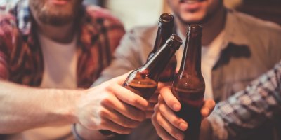 Muži si připíjí pivem v lahvích.
