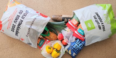 Dvě ležící tašky Globus naplněné potravinami 