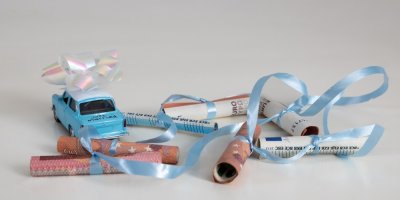 Srolované bankovky ovázané stužkou, model autíčka