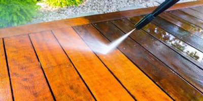 Čištění dřevěné terasy vapkou, půlka prken je světlejší, nevyčištěná polovina je tmavší