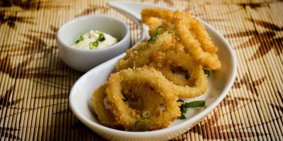 Cibulové kroužky na bílém oválném talíři