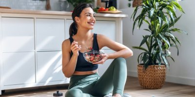 Mladá žena v atletickém oblečení jí musli s ovocem