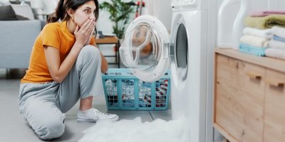 Žena vyděšeně sleduje vyteklou pračku