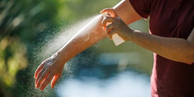 Muž si aplikuje repelent