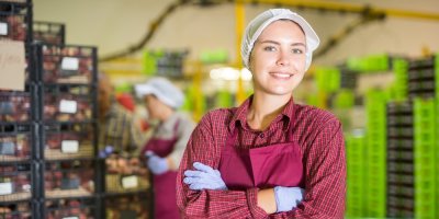 Pracovnice skladu v supermarketu, v pozadí krabice se zbožím