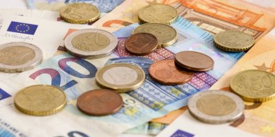 Eurové mince a bankovky různě poházené na sobě