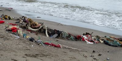 Vyhozené oblečení vyplavené z moře na pláž