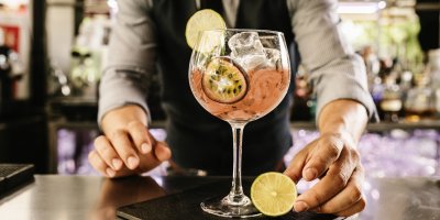 Barman se sklenicí vinného střiku s ledem, limetou a marakujou