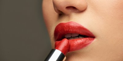 Žena si nanáší červenou rtěnku