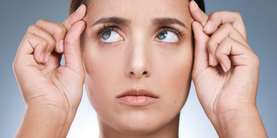 Žena se drží za pleť