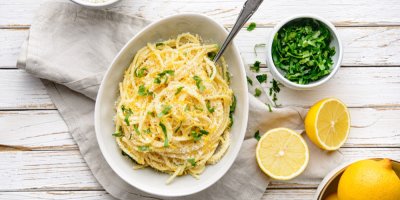 Hluboký talíř se špagetami posypanými parmazánem a petrželovou natí