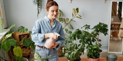 Žena rozprašovačem stříká rostliny