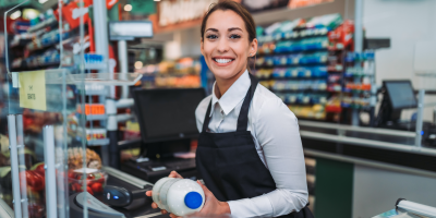 Mladá pokladní markuje láhev mléka