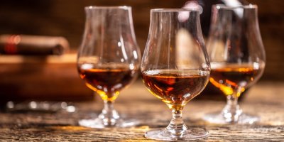 Tři skleničky s rumem stojí na stole.