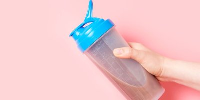 Proteinový šejkr na růžovém pozadí