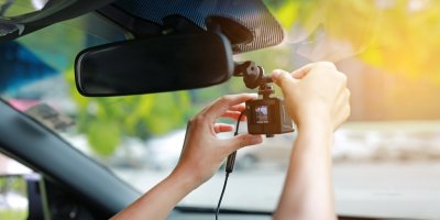 Ruce instalují autokameru u zpětného zrcátka