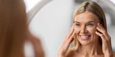 Žena si aplikuje oční krém