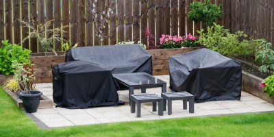 Venkovní nábytek na zahradě přikrytý ochrannými plachtami
