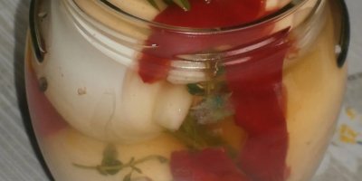 Detail sklenice s naloženými vejci, česnekem, paprikou a bylinkami