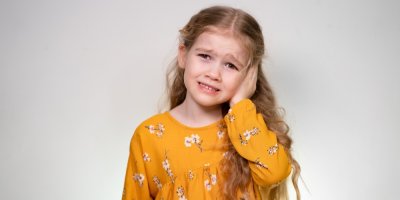 Holčička se drží za ucho