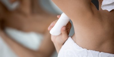 Žena si aplikuje antiperspirant do podpaží