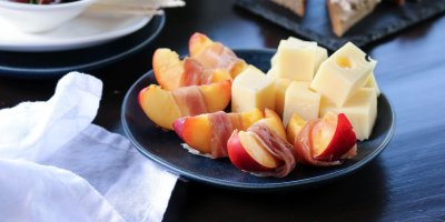 Talířek s nakrájenými nektarinkami obalenými plátky šunky a kostkami sýra