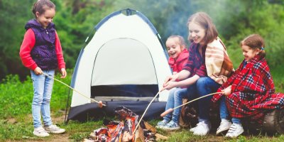 Rodina opéká špekáčky na ohni