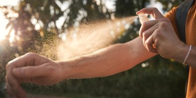 Muž si aplikuje repelent