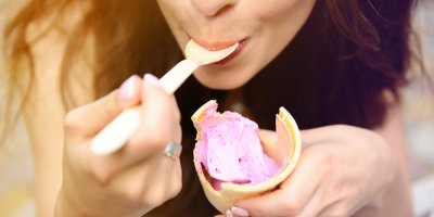 Žena jí zmrzlinu růžové barvy