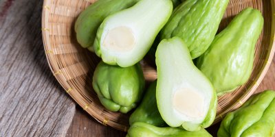 Rozříznutý čajot a jeho další plody ležící v proutěné míse