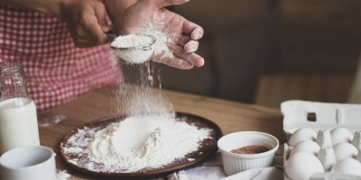 Žena sype mouku na talíř