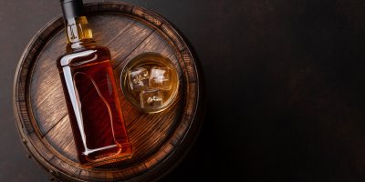 Lahev a sklenice whisky na sudu
