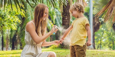 Žena aplikuje repelent na chlapcovu ruku