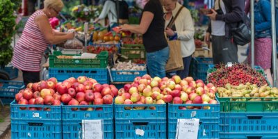 Bedny s ovocem, v pozadí lidé na trhu 