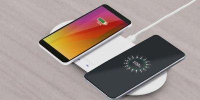 Bílá duální bezdrátová nabíječka nabíjí dva telefony. 