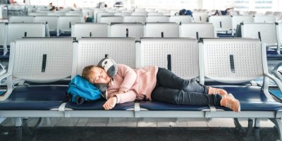 Dívka spí na letišti na sedačkách