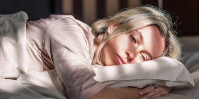 Žena leží a smutně se dívá