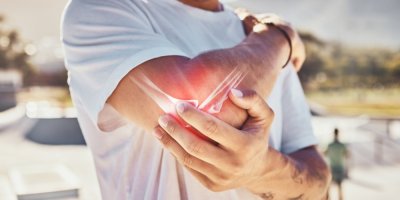 Muž se drží za loket