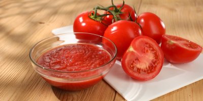 Miska rajčatového pyré a rajčata vedle ní