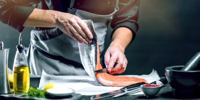Kuchař čistí filet lososa.