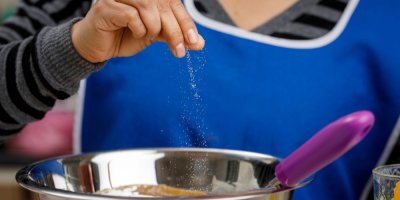 Ženská ruka přidává do mísy špetku soli.