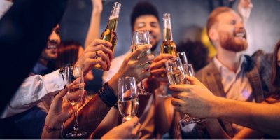Skupinka lidí si přiťukává alkoholem